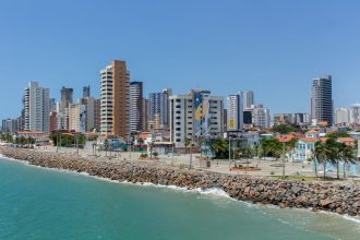 Vista da orla e do skyline de Fortaleza, com edifícios modernos junto à costa.