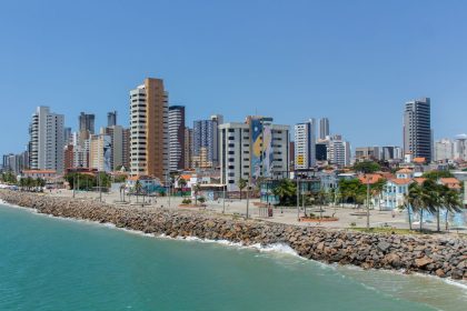 Vista da orla e do skyline de Fortaleza, com edifícios modernos junto à costa.