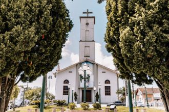 Igreja católica cercada por árvores, em um dia ensolarado, no estado de Goiás.