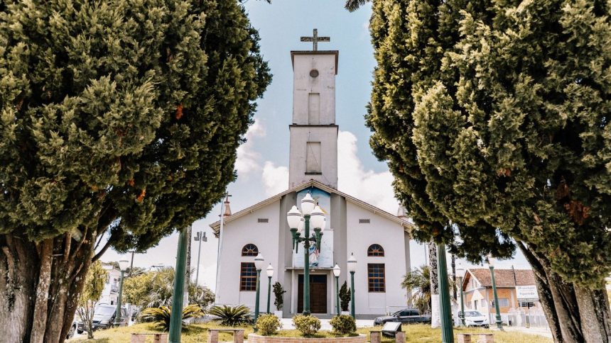 Igreja católica cercada por árvores, em um dia ensolarado, no estado de Goiás.