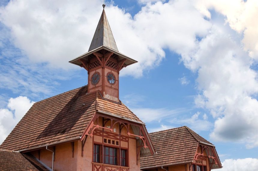 Vista externa do Museu da Imigração e Ferroviário de Joinville, com sua torre histórica em um dia ensolarado.